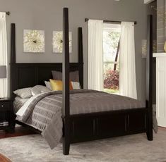 a four poster bed in a bedroom with gray walls