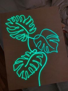 a lit up piece of paper that has a plant on it with leaves in the middle