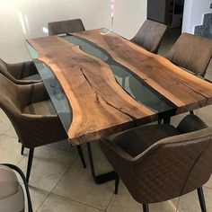 a dining table made out of wood and glass with leather chairs around it in a room