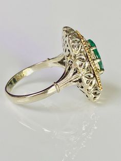 Beautiful vintage 18K yellow and white gold emerald ring. The openwork filigree work white gold setting has a lovely gold detail surrounding a pronged marquise cut emerald (approx. 9.9mm x 5.7mm). The ring measures approx. 19.2mm from north to south and 13mm from east to west. The ring is currently sized at 6.5 and marked 18k. 5.3 grams total weight. Classic Gold Marquise Emerald Ring, Classic Marquise Emerald Ring In Gold, Elegant Marquise Ring With Intricate Design, Heirloom Marquise Emerald Ring, Heirloom Gold Marquise Cut Emerald Ring, Heirloom Marquise Cut Gold Emerald Ring, Fine Jewelry Emerald Ring With Intricate Design, Formal Marquise Yellow Gold Emerald Ring, Formal Marquise Jewelry With Intricate Design