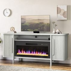 an entertainment center with a television and fire place in front of the tv on top of it