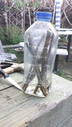 an empty glass bottle sitting on top of a wooden table next to a pair of scissors