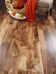 a living room with wood flooring and an orange blanket on the chair next to it