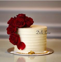 a white cake with red roses on top