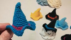 there are crocheted hats on the table and one is wearing a blue hat