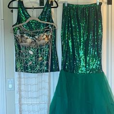 two green dresses hanging on the wall