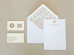 the stationery is laid out on top of the envelope and business cards, which are also in gold foil