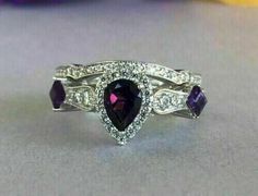 a purple and white diamond ring on a table