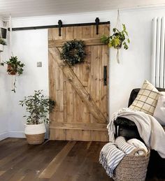 a living room with a wooden door and potted plants