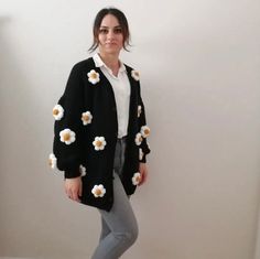 🌼 Effortlessly chic and cozy, our Daisy Knit Cardigan is the perfect addition to any wardrobe. Embrace the elegance and warmth of this exquisite cardigan sweater, tailored for those who appreciate the finer things in life. 💐 Unique Floral Cardigan: Stand out with our charming floral design, featuring delightful daisies that add a touch of spring to your look year-round. Be the epitome of grace with this captivating oversized cardigan that's both stylish and comfortable. 🖤 Timeless Black Cardi Daisy Cardigan Outfit, Woolen Cardigan Design, Woolen Cardigans For Women, Cozy Black Sweater For Spring, Cozy Black Spring Sweater, Cozy Black Sweater Coat For Spring, One Size Sweater Coat For Spring, Cozy Black Spring Cardigan, Chic Black Knitted Cardigan