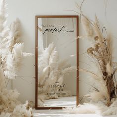 a mirror sitting on top of a white floor next to dry grass and pamodia