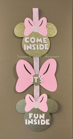 some pink and silver minnie mouse cut outs on a brown background with the words come inside