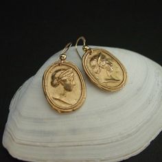 Handmade intaglio reproduction showing the birthing goddess Hera. Hera was a powerful goddess, the wife and sister of Zeus. She was worshiped as the Queen of Heaven as well as the Goddess of Marriage, Women and Birth. Roman equivalent Juno. - Handmade cameos - Solid yellow bronze also called jeweler gold bronze cameos. - 14k gold filled ear wire. - Gold filled has 100 times more gold than plated so does not rub or peel off. - Nickel free. - Reproduction of a 17th c. Victorian cameo. - Signed in Gold Hand Cast Dangle Earrings, Symbolic Bronze Drop Earrings, Brass Medallion Earrings For Pierced Ears, Brass Medallion Earrings As A Gift, Yellow Gold Medallion Brass Earrings, Artisan Gold Oval Earrings, Elegant Hand Cast Brass Earrings, Handmade Yellow Gold Plug Earrings, Hand-cast Brass Dangle Earrings