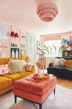 a living room filled with colorful furniture and pictures hanging on the wall above it's coffee table