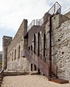 an old stone building with stairs leading up to the second floor and another one on the other side