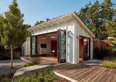 a small white house sitting on top of a wooden deck