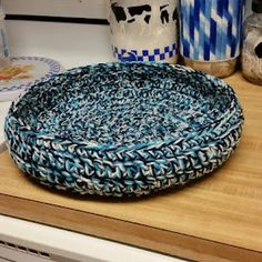 a blue and white bowl sitting on top of a wooden counter next to two vases