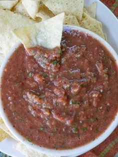 a white bowl filled with salsa and tortilla chips on top of a table