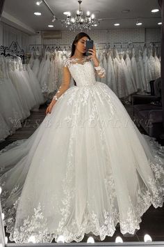 a woman taking a selfie in front of a mirror with her wedding dress on