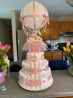 a wedding cake made to look like a hot air balloon with flowers in the background