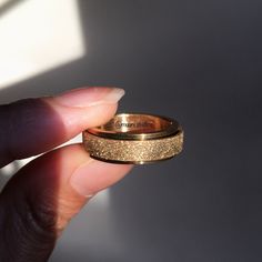 a person holding a gold ring in their hand