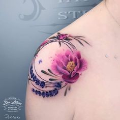 a woman's shoulder with a flower tattoo on the left side of her breast