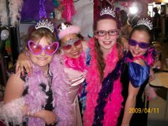 three girls wearing pink and purple costumes posing for the camera with their tiaras on