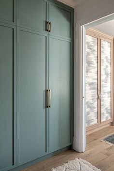 an empty room with blue cabinets and white rugs on the wooden floor next to it