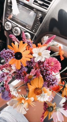 a bouquet of flowers sitting in the center console of a car