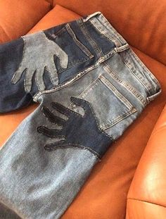 an old pair of jeans sitting on top of a leather couch