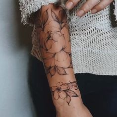 a woman with a flower tattoo on her arm