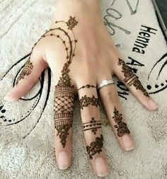 a woman's hand with henna tattoos on it