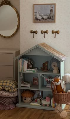 there is a doll house in the corner of this child's room with toys