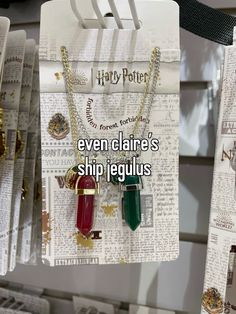 two harry potter necklaces are hanging on the clothes line in front of newspaper clippings