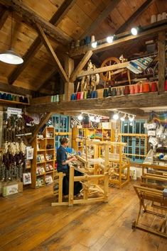 a person working in a wooden shop with lots of crafting supplies on the shelves