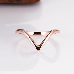 a rose gold ring with a curved band