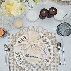 a table set with plates, silverware and napkins