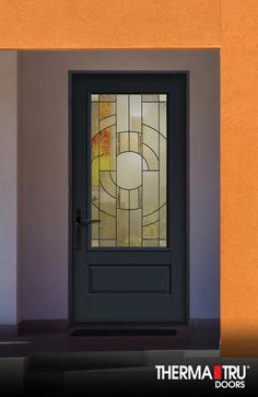 a black door with stained glass in front of an orange wall and the words thermal doors on it