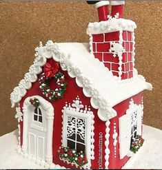 a red and white gingerbread house decorated for christmas