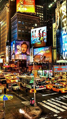 a busy city street filled with lots of traffic and tall buildings in the night time