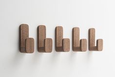 five wooden pegs are lined up on the wall