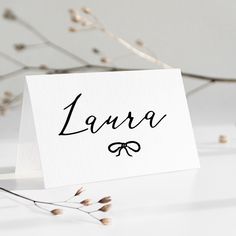 a white card with the word lazza written in cursive ink on it