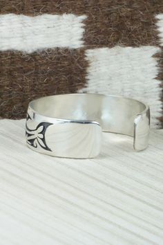 This sterling silver bracelet was made by Hopi silversmith Timothy Mowa. The inside is signed and stamped sterling.Size: 5 3/4" (will fit up to a 6 1/4" wrist)Gap: 3/4"Width: 3/4"Free shipping on all orders! We ship with USPS and always include tracking. All orders ship within a day of payment.Returns are accepted up to 30 days after you receive your order. Just send us a message. Our shop offers cash back or store credit. The item must be returned in new condition. Symbolic Engraved Sterling Silver Cuff Bracelet, Southwestern Sterling Silver Polished Bangle Bracelet, Southwestern Sterling Silver Bangle With Polished Finish, Southwestern Polished Sterling Silver Bangle, Silver Southwestern Style Cuff Bracelet For Formal Occasions, Sterling Silver Etched Bangle Bracelet, Southwestern Polished Cuff Bracelet As Gift, Etched Sterling Silver Bangle, Southwestern Engraved Cuff Bracelet As A Gift