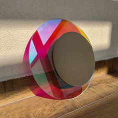 a circular object sitting on top of a wooden floor next to a wall and window