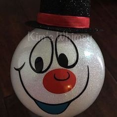 a white ball with a clown face painted on it's side and a black top hat