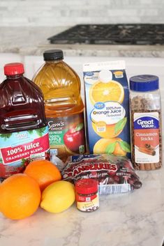 an assortment of fruit and juices on a kitchen counter