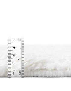 a white fur rug with a measuring tape