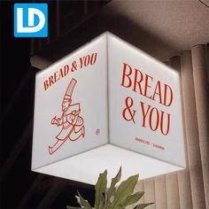 a white light hanging from the side of a building with bread and you on it