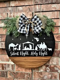 a wooden sign hanging on the side of a brick wall with a christmas nativity scene