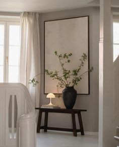 a black vase sitting on top of a table next to a white crib filled with flowers